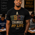 Man wearing the A HBCU Changed My Life tee by Just My Baby Daddy, varsity HBCU lettering in green, gold, maroon and navy on black